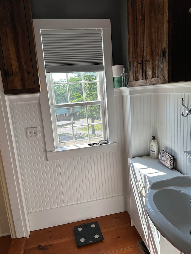 laundry room featuring sink and dark hardwood / wood-style flooring