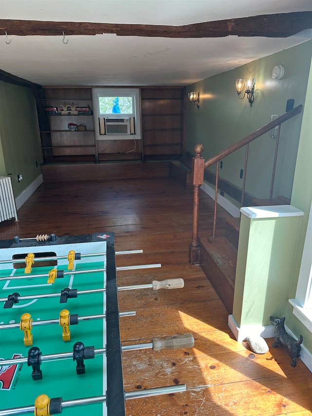 interior space with radiator heating unit, cooling unit, and hardwood / wood-style flooring