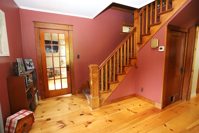 entrance foyer featuring crown molding and light wood-type flooring