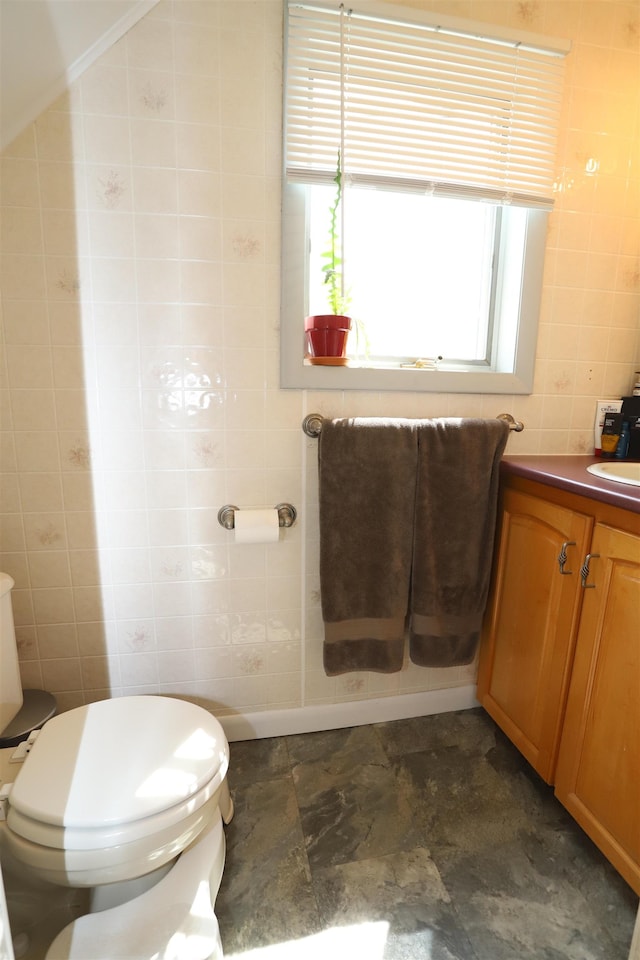 bathroom featuring tile walls, vanity, and toilet