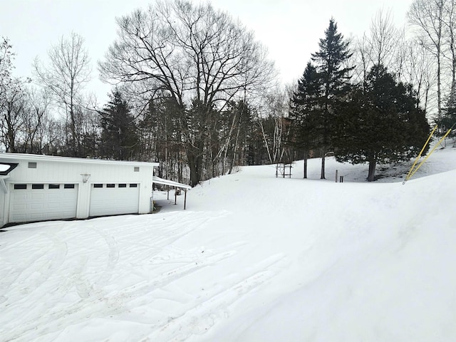 yard layered in snow featuring a garage