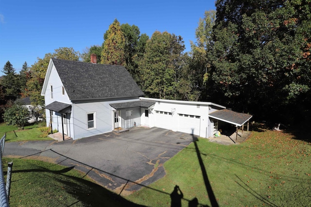 exterior space with a garage, a carport, and a front yard