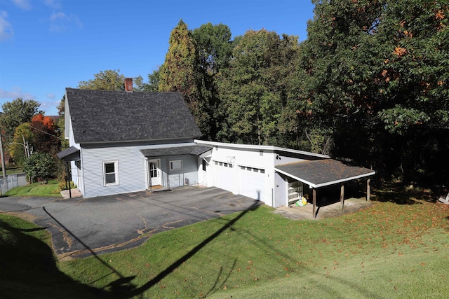 view of front facade featuring a carport, a garage, and a front yard