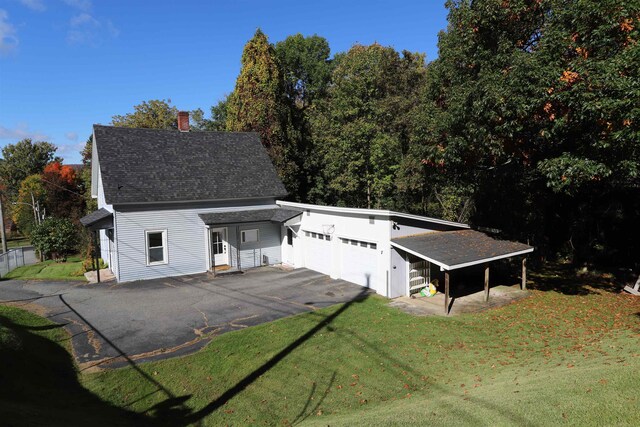 view of front of house featuring a carport, a garage, and a front yard