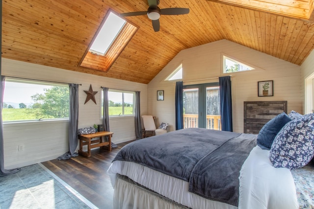 tiled bedroom with lofted ceiling with skylight, wooden walls, wooden ceiling, and ceiling fan