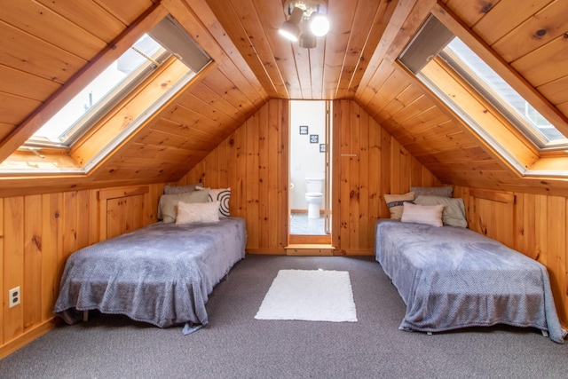 carpeted bedroom featuring lofted ceiling with skylight and wooden ceiling