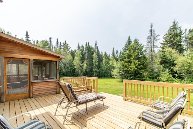 wooden deck featuring a lawn and a sunroom