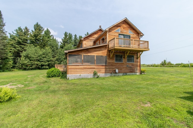 rear view of house with a wooden deck, a sunroom, and a lawn