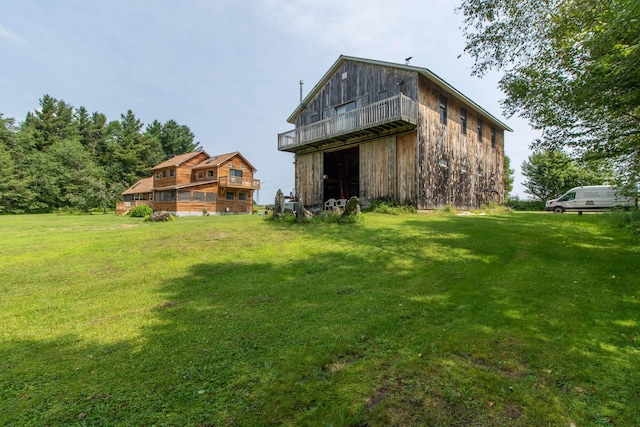 rear view of house featuring an outbuilding and a yard