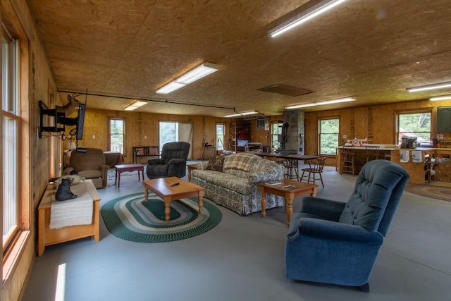 living room with concrete floors and wood walls