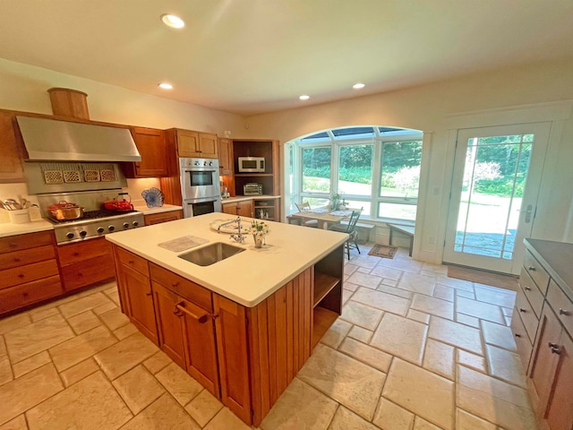 kitchen featuring sink, a center island with sink, extractor fan, and appliances with stainless steel finishes