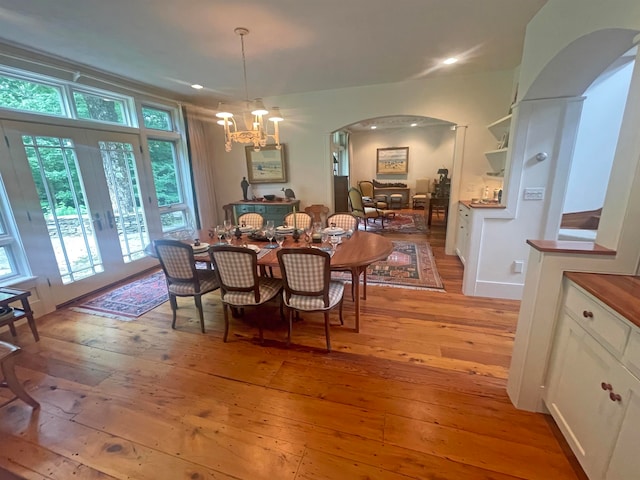 dining room featuring a chandelier, french doors, and light hardwood / wood-style flooring