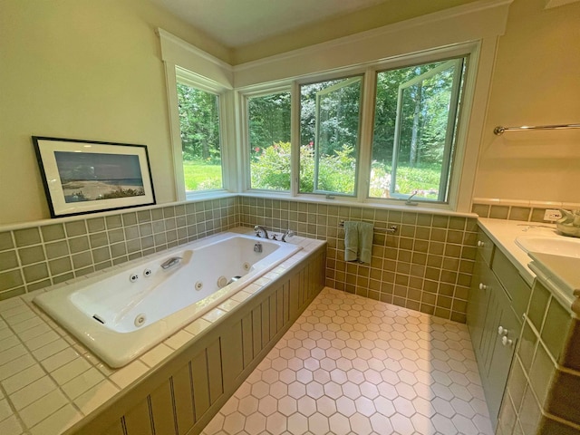 bathroom with a washtub, vanity, tile patterned flooring, and a wealth of natural light