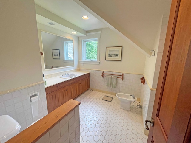 bathroom featuring tile patterned floors, vanity, tile walls, and a bidet