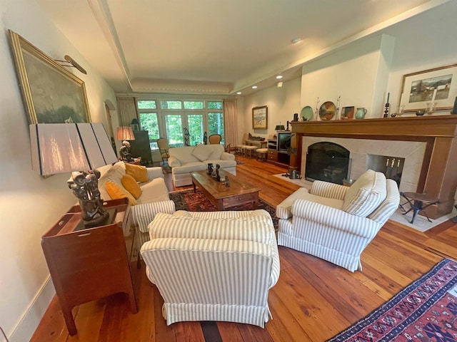 living room featuring wood-type flooring and a tray ceiling