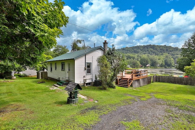 view of side of property featuring a yard and a deck