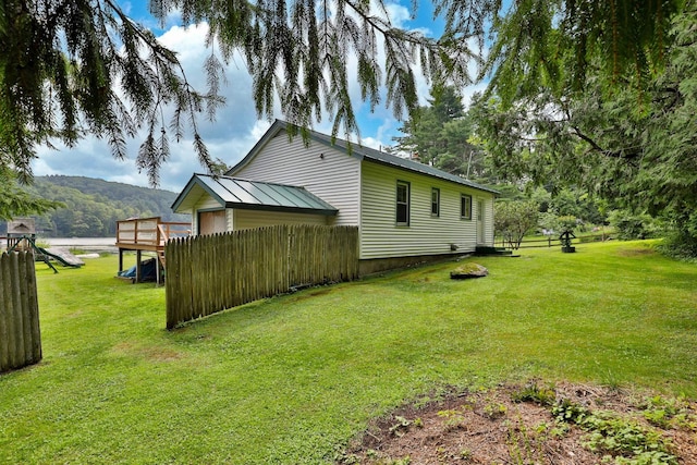 view of property exterior with a yard and a deck with mountain view