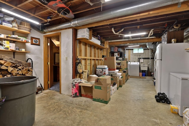 basement with washer / dryer, sink, and white fridge