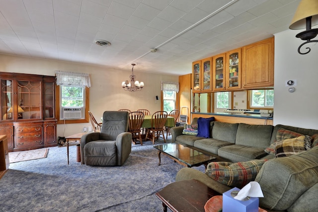 living room featuring cooling unit, carpet floors, and a chandelier