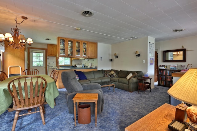 carpeted living room featuring an inviting chandelier