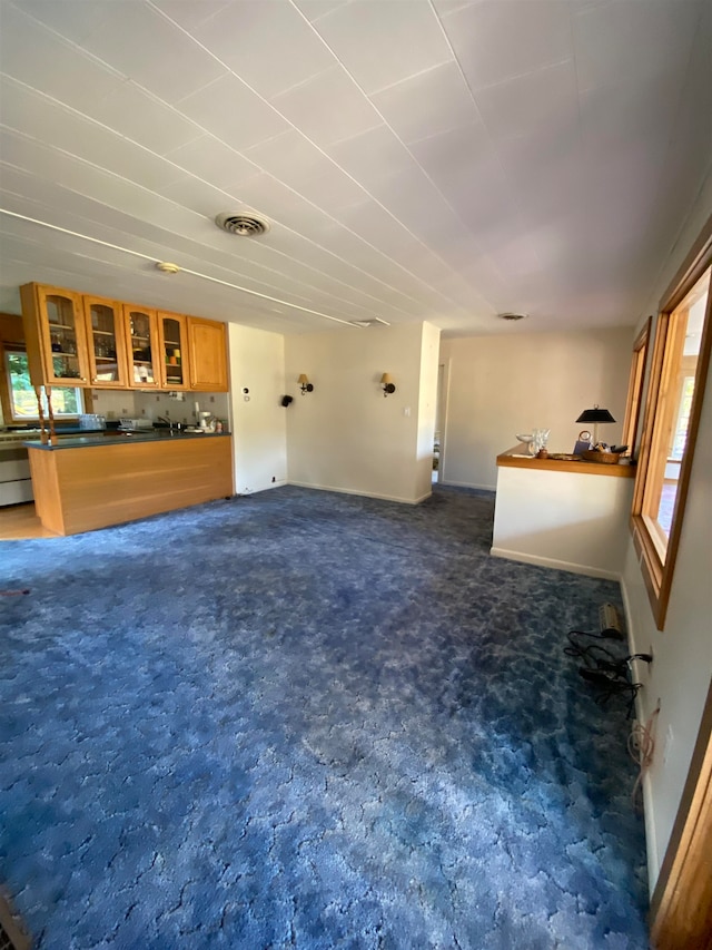 unfurnished living room with dark colored carpet