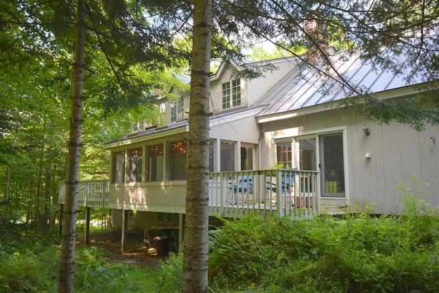 back of property featuring a wooden deck and a sunroom