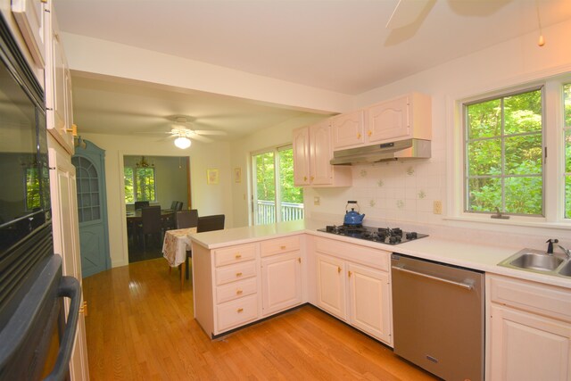 kitchen featuring ceiling fan, kitchen peninsula, stainless steel dishwasher, black gas cooktop, and white cabinetry