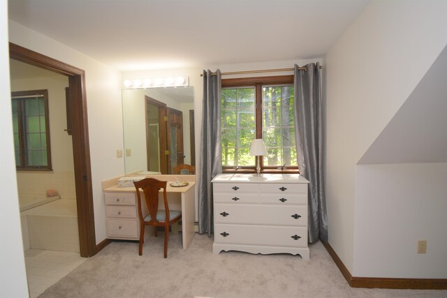 bedroom with light colored carpet and ensuite bathroom