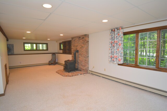 basement featuring carpet, a wood stove, and a baseboard radiator