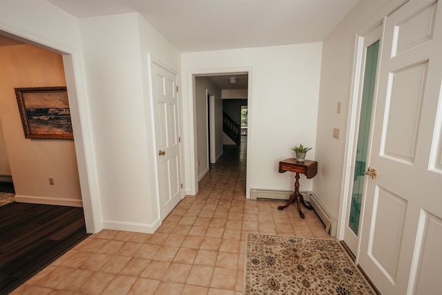 hallway featuring a baseboard radiator and light tile patterned floors