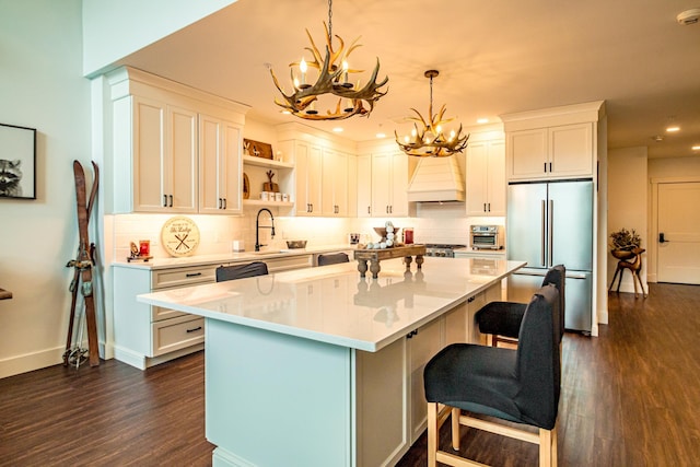 kitchen featuring premium range hood, open shelves, high end refrigerator, white cabinets, and dark wood-style flooring