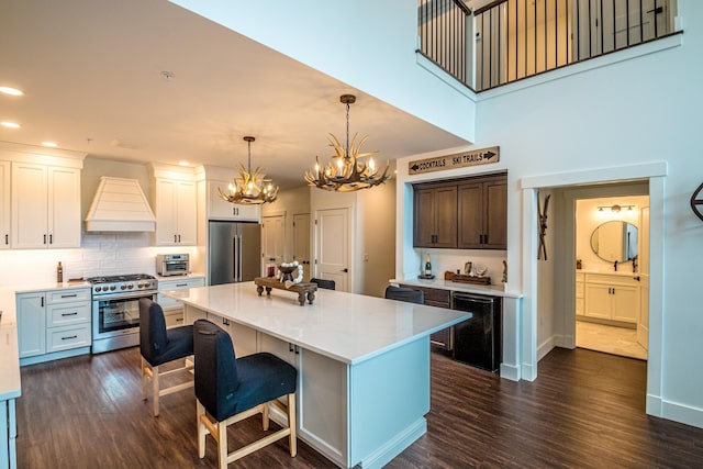 kitchen featuring appliances with stainless steel finishes, beverage cooler, dark wood-style flooring, and custom range hood