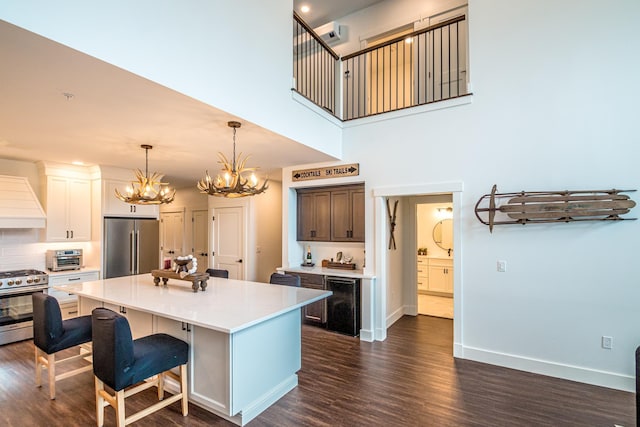 kitchen featuring a kitchen island, dark wood-type flooring, appliances with stainless steel finishes, and custom range hood