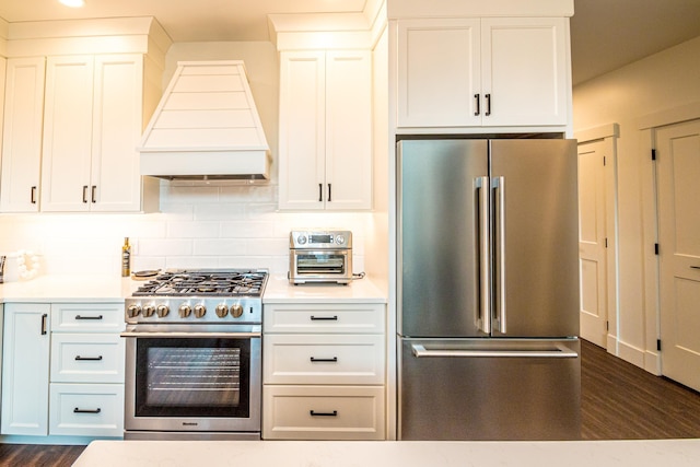 kitchen featuring light countertops, custom range hood, decorative backsplash, white cabinets, and high end appliances