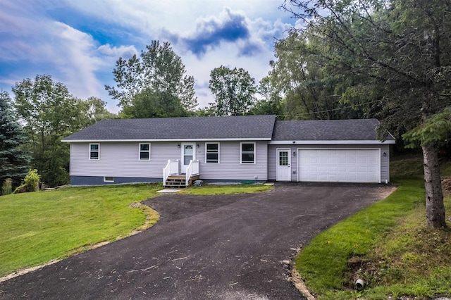 ranch-style home featuring driveway, roof with shingles, an attached garage, and a front yard