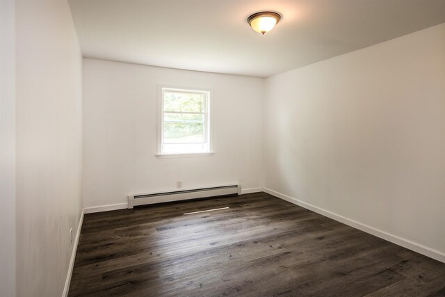 spare room with dark wood-style floors, a baseboard radiator, and baseboards