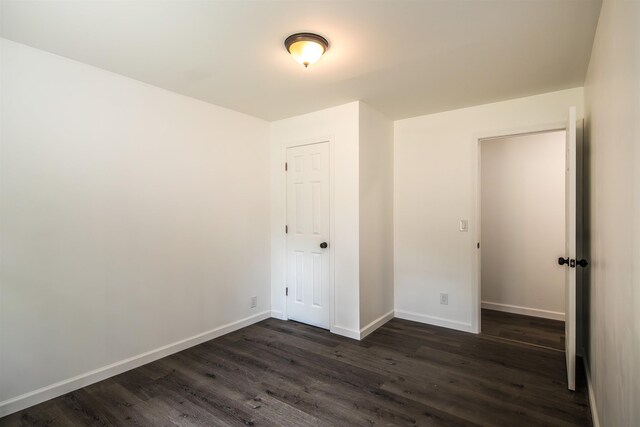 unfurnished bedroom featuring dark wood-style floors and baseboards