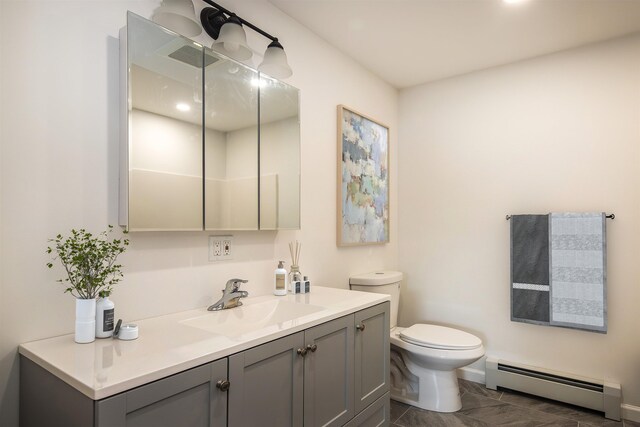 bathroom with toilet, marble finish floor, a baseboard heating unit, and vanity