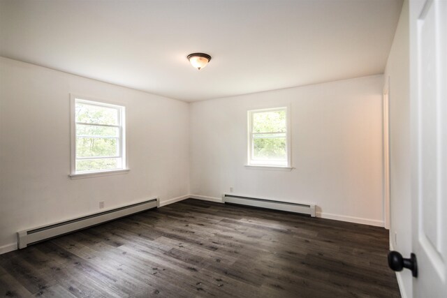 empty room featuring dark wood-style floors, baseboards, and baseboard heating