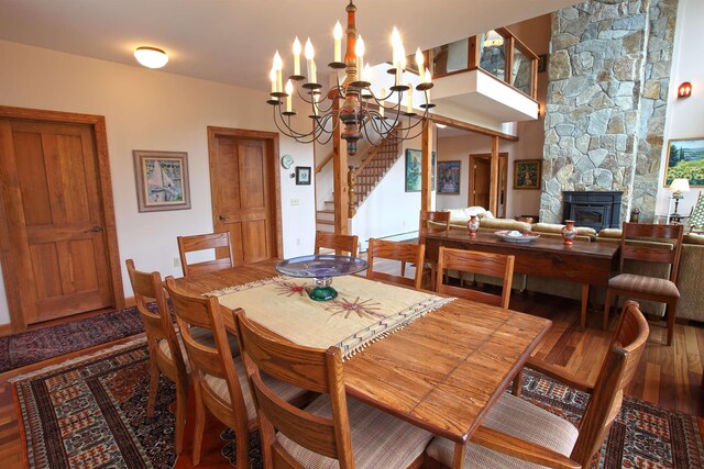 dining area featuring hardwood / wood-style flooring, a fireplace, and a chandelier