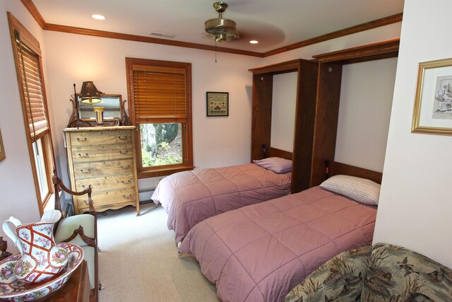 carpeted bedroom featuring a baseboard heating unit, crown molding, and ceiling fan