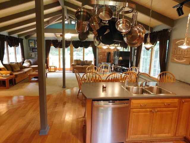 kitchen featuring lofted ceiling with beams, plenty of natural light, dishwasher, and sink