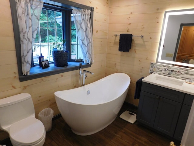 bathroom featuring a bathing tub, wood-type flooring, wooden walls, and toilet