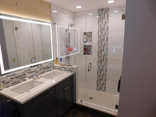 bathroom featuring tasteful backsplash, vanity, and a shower with shower door