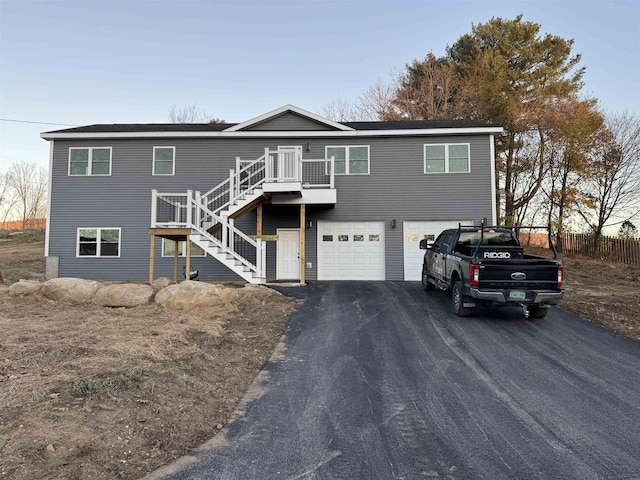 view of front of home featuring aphalt driveway, stairway, and an attached garage