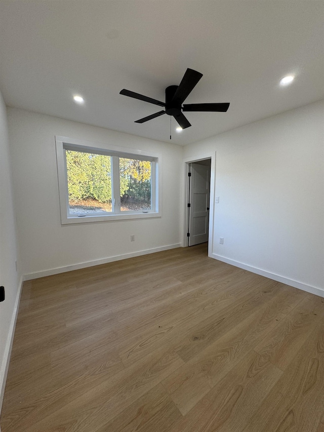 empty room featuring light wood finished floors, recessed lighting, a ceiling fan, and baseboards