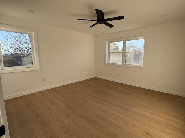 empty room featuring ceiling fan, wood finished floors, and baseboards