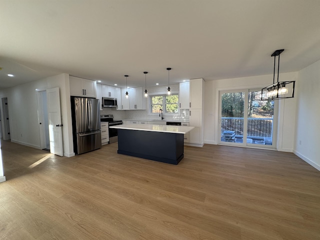 kitchen featuring tasteful backsplash, white cabinetry, appliances with stainless steel finishes, and light countertops