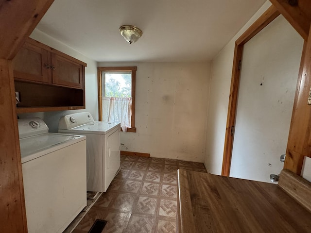 laundry room with cabinet space, light floors, and washing machine and clothes dryer