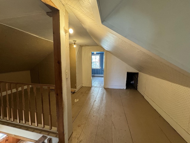 additional living space featuring vaulted ceiling and wood-type flooring